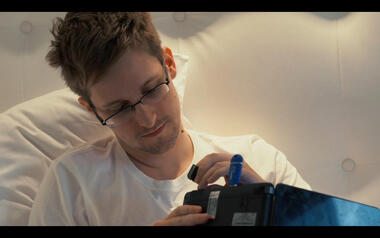 Snowden conectando una tarjeta SD en un portátil con una memoria USB azul de Tails